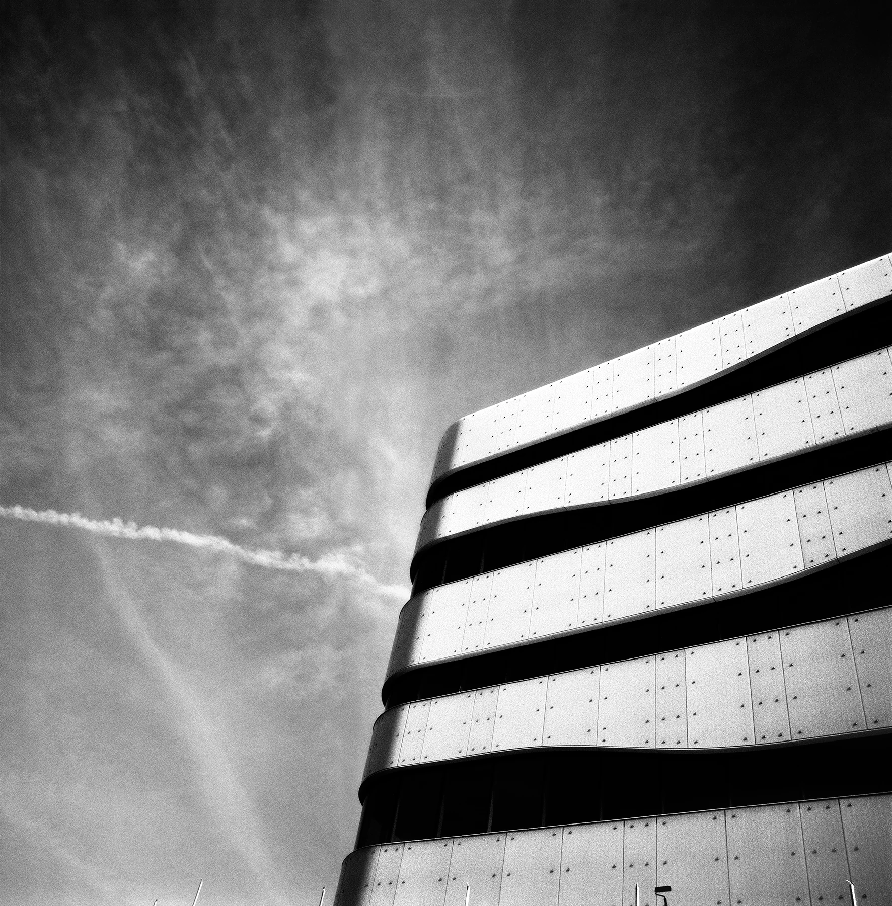 Slatted structure against a cloudy sky