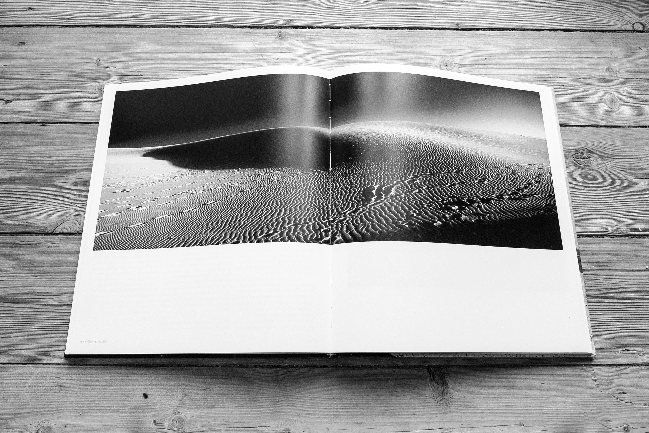 Open photography book showing a sand landscape