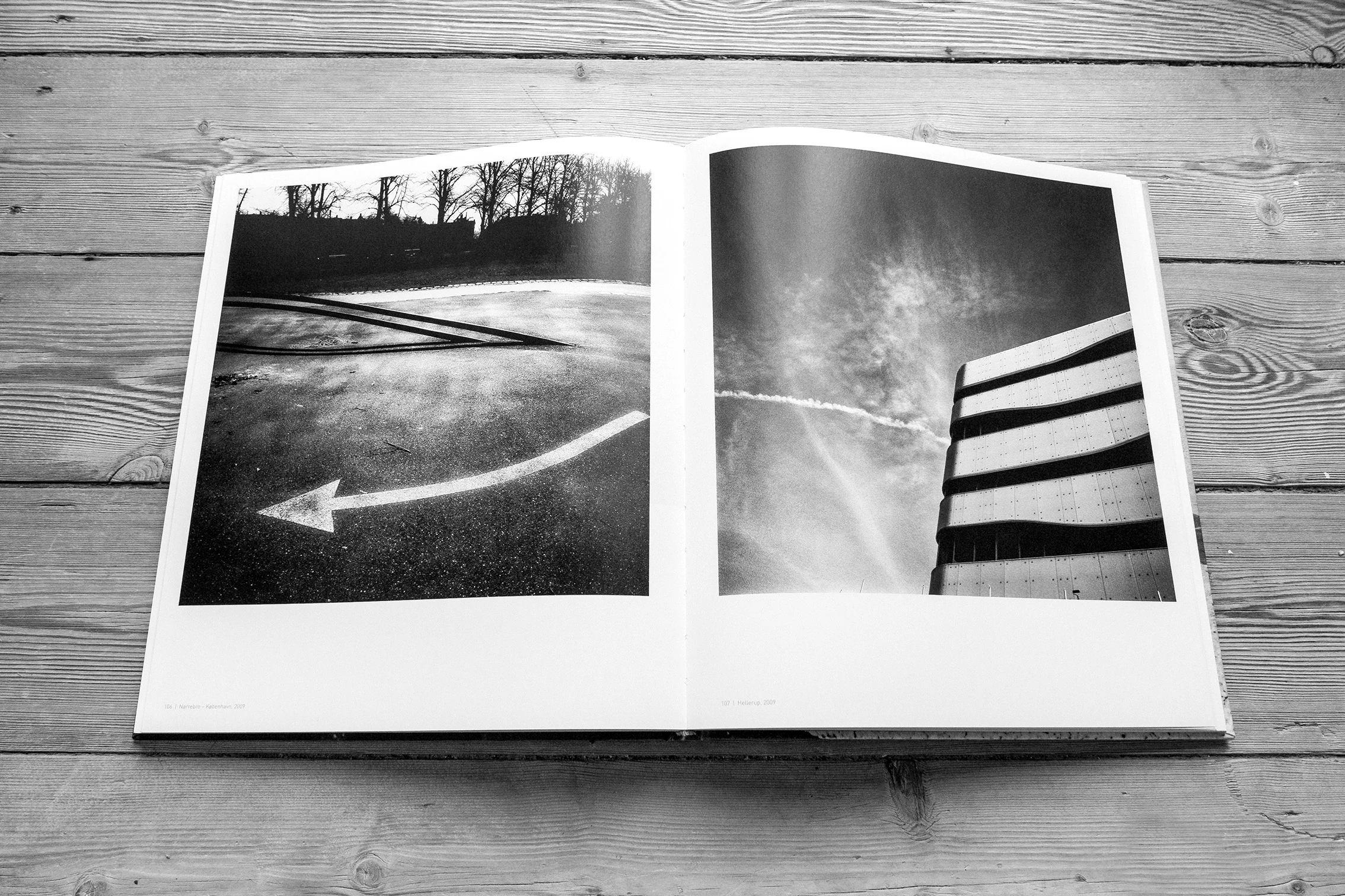 Book spread with monochrome landscape and architecture photographs
