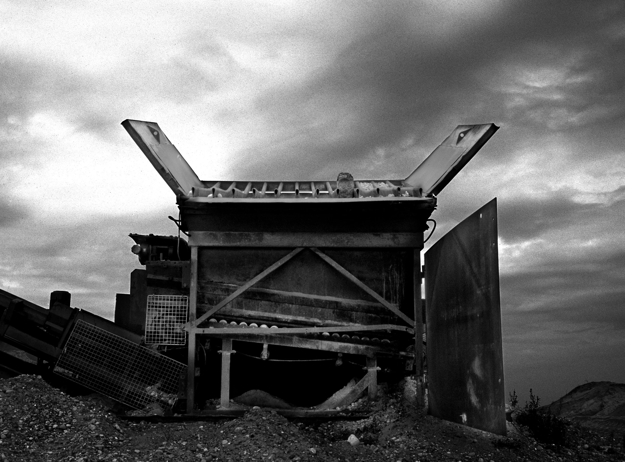 Stone sorting machine beneath a cloudy sky