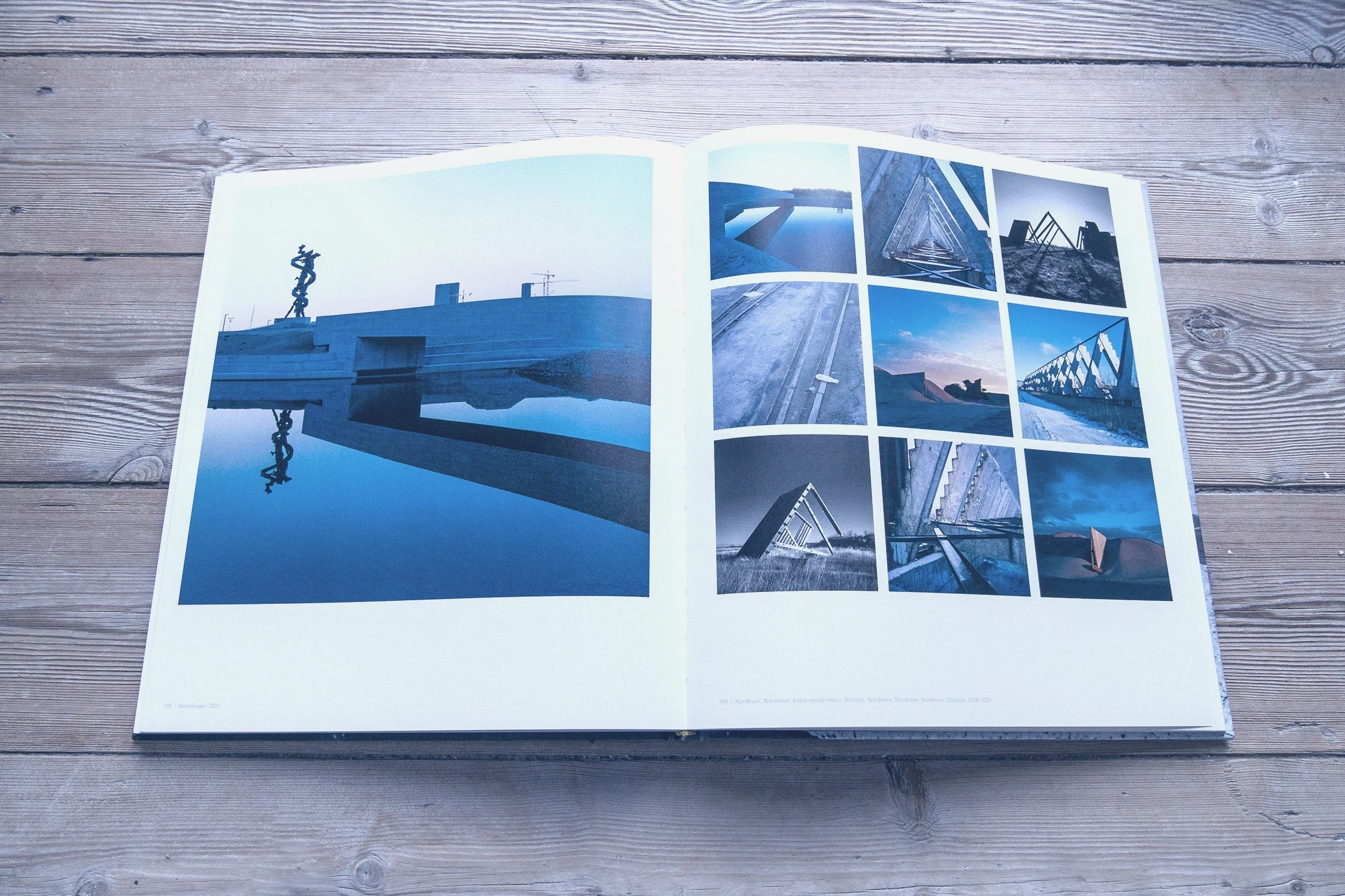Book spread with blue-toned architecture photographs
